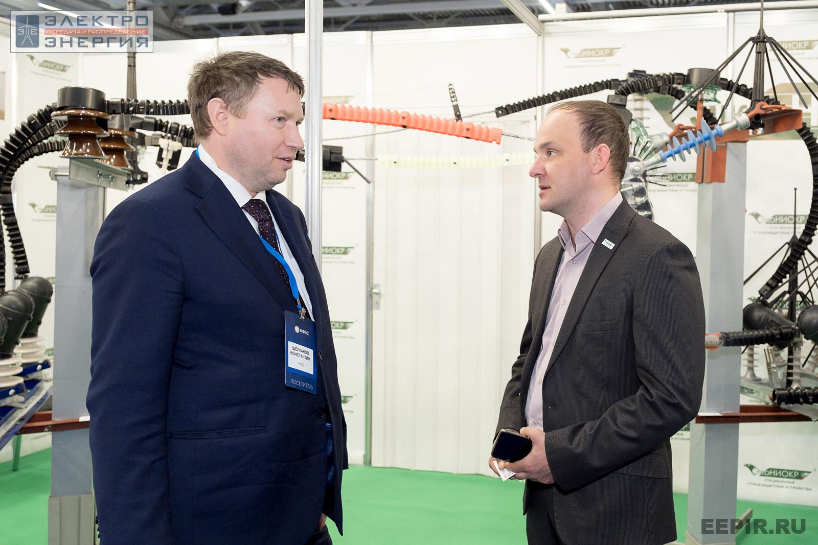 Участники МФЭС-2022 общаются на фоне стенда «Эко-НИОКР»