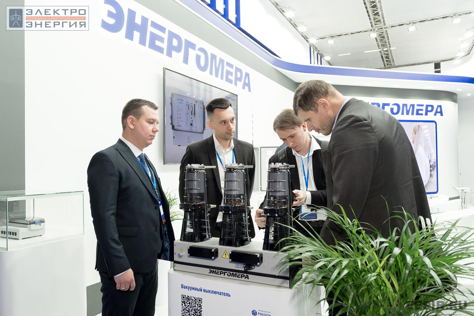 Специалисты рассматривают вакуумный выключатель на стенде АО «Энергомера»