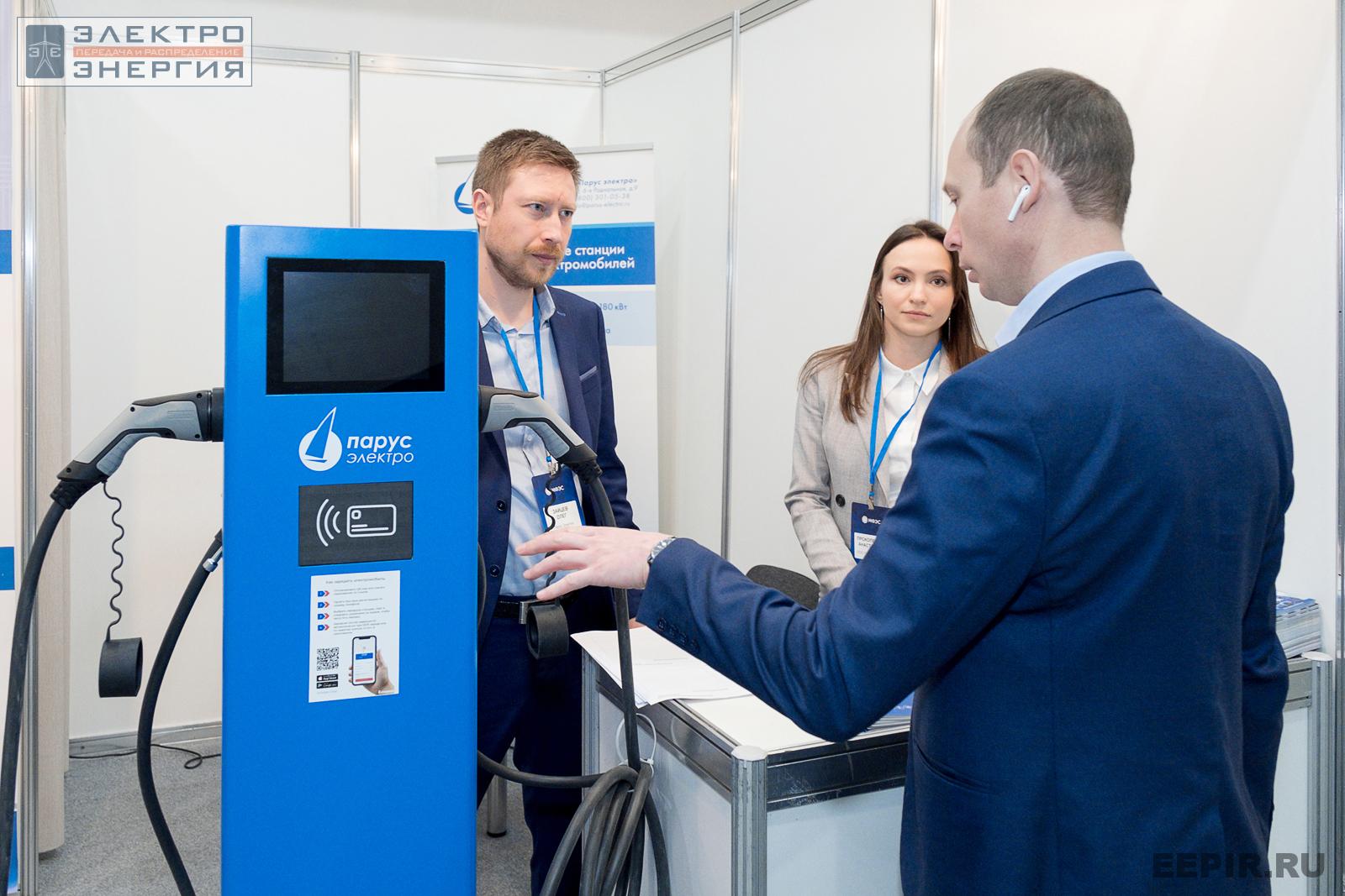 Посетитель МФЭС-2022 интересуется зарядной станцией для электротранспорта на стенде ООО «Парус электро»