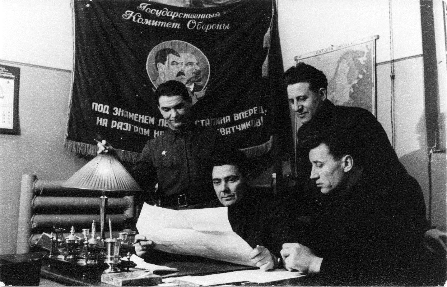 Начальник строительства Н.Я. Тарасов и главный инженер Ф.В. Сапожников (сидят, слева направо) обсуждают план восстановления Дубровской ГРЭС. 1944 г. Фото из архива семьи Сапожниковых